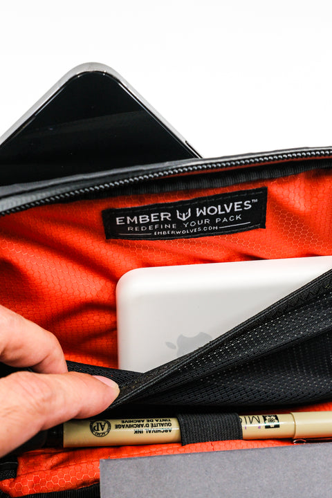 Alpha Pack interior close up showing magsafe battery, pen, notebook and label | Color: Black VX | Size: 1.8L