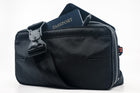 An Alpha Pack shown from the front with passport, pen and phone sticking out and strap with fidlock buckle draped over the front | Color: Black VX | Size: 2.6L