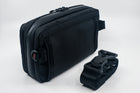 An Alpha Pack shown from the back at a three quarter angle with rolled up strap and Fidlock buckle  | Color: Black VX | Size: 2.6L