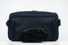 An Alpha Pack shown from the back with rolled up strap and Fidlock buckle | Color: Black VX | Size: 2.6L