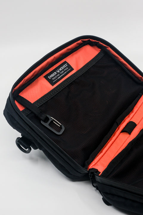An Alpha Pack shown open and cropped so you can only see the top portion and built in carabiner and label | Color: Black VX | Size: 2.6L