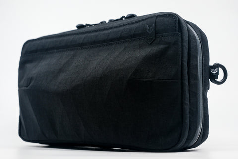 An Alpha Pack with a small white logo, shown from a three-quarters angle. | Color: Tactical Black | Size: 2.6L