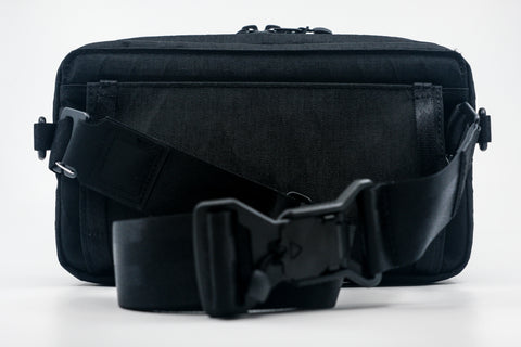 An Alpha Pack with an adjustable black webbing strap and fidlock buckle | Color: Tactical Black | Size: 2.6L