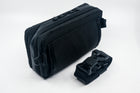 An Alpha Pack with detached strap and buckle rolled up. | Color: Tactical Black | Size: 2.6L
