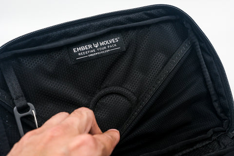 Close-up of the interior of an Alpha Pack showing the mesh fabric lining, zipper track, and an Ember Wolves brand label. | Color: Tactical Black | Size: 2.6L